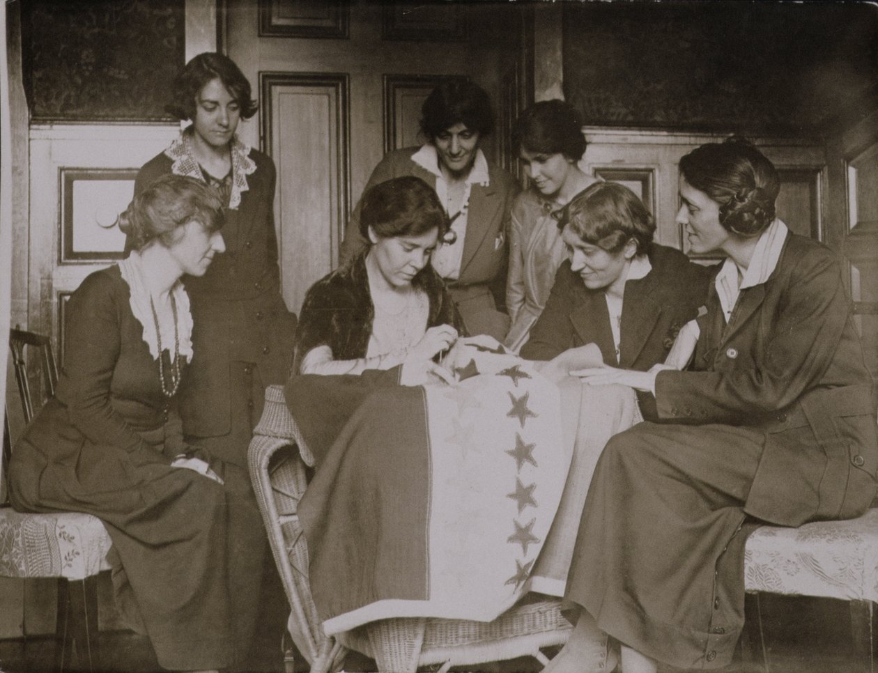 Alice Paul näht Sterne auf die Frauenwahlrechtsflagge, während andere Frauen zuschauen, um 1920 von American Photographer