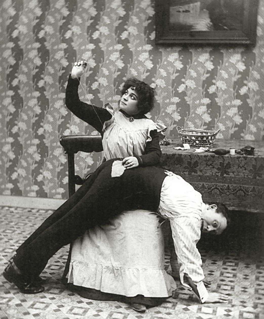 Frau näht einen Riss in einer Männerhose, um 1895 von American Photographer