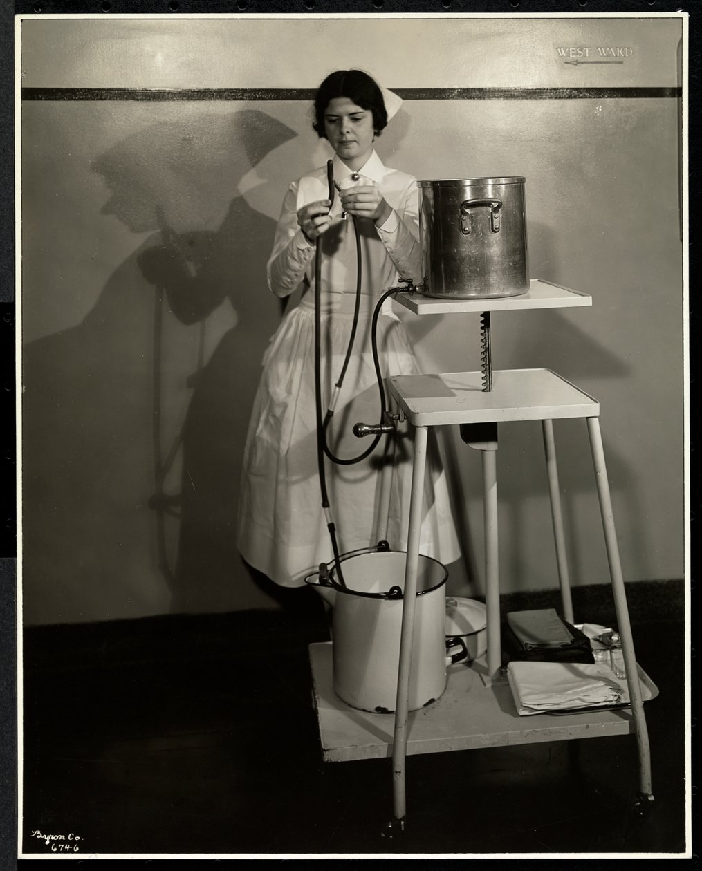 Eine Krankenschwester demonstriert ein spezielles Gerät mit Schläuchen und Eimern im Sloan Maternity Hospital, Broadway und 168th Street, New York, 1932 von Byron Company