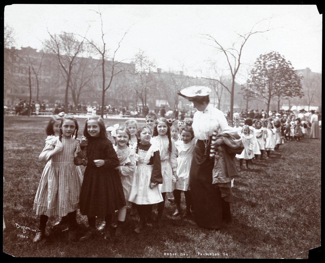 Kinder in einer langen Reihe, geführt von einer Frau am Arbor Day im Tompkins Square Park, New York, 1904 von Byron Company