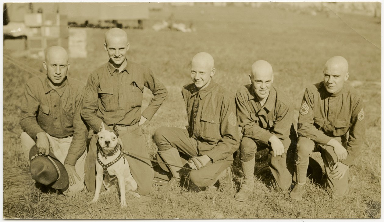 Fünf Soldaten knien im Gras und posieren für ein Bild mit einem Hund an der Leine von Carl Michel