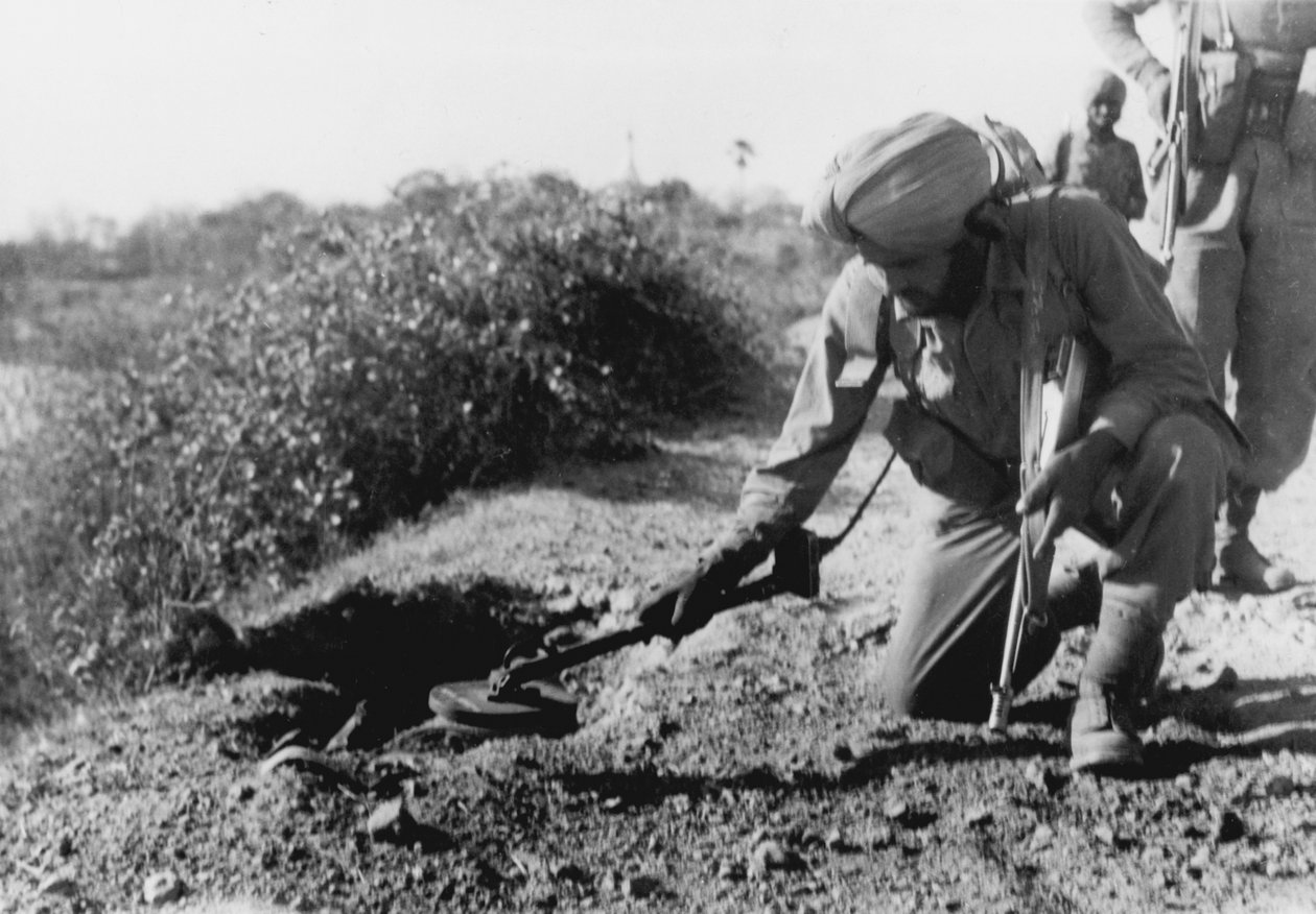 Ein indischer Soldat sucht mit einem Metalldetektor nach Minen von English Photographer