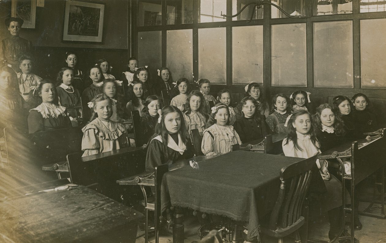 Mädchen sitzen in einem Klassenzimmer von English Photographer