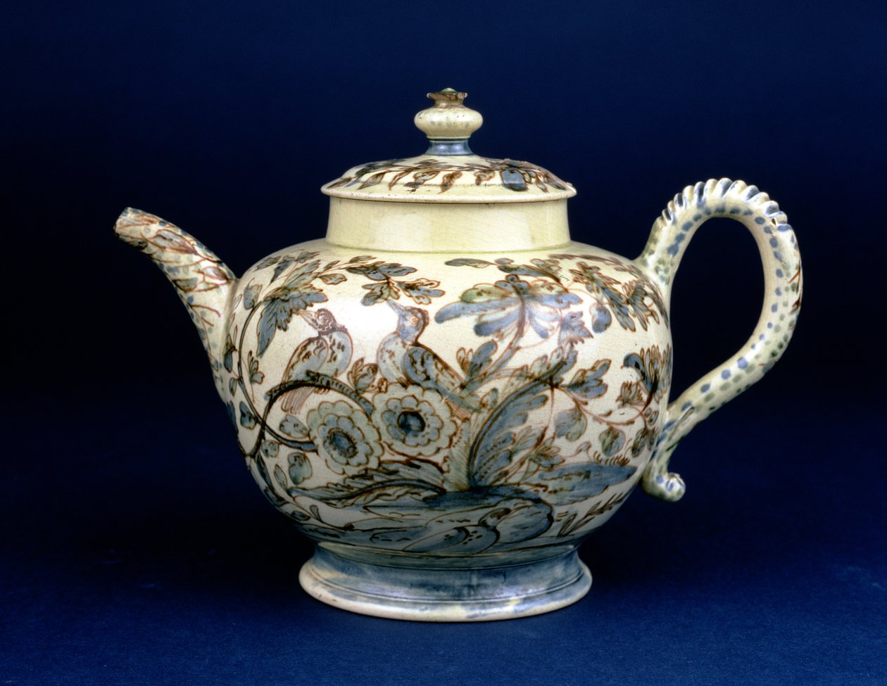 Staffordshire Creamware-Teekanne, bekannt als die Tunstall-Teekanne, dekoriert mit drei Vögeln in orientalischem Laubwerk, bemalt in bräunlichem Mangan, die Umrisse in Blau und Grün unterglasur von F. Morg von English School