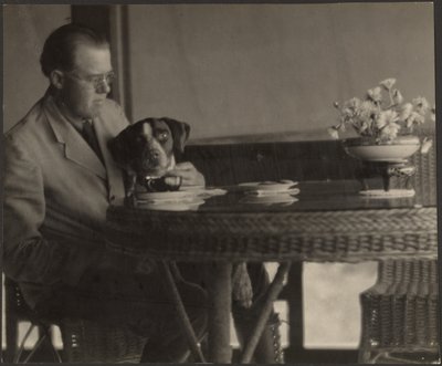 Mann und Hund am Tisch sitzend von Louis Fleckenstein